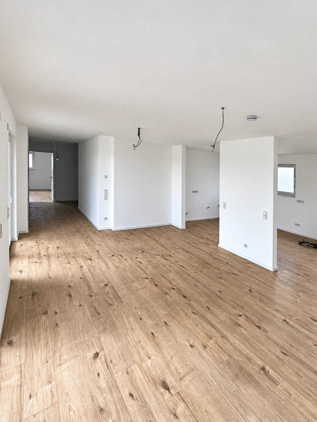 Heller Innenraum mit weißen Wänden und Boden in Holzoptik